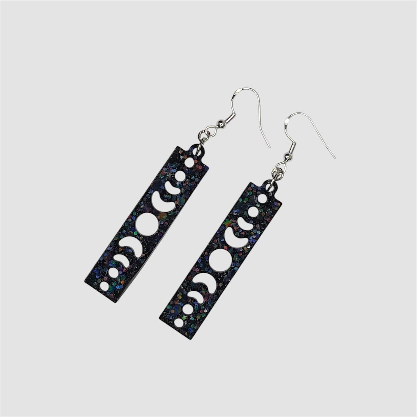 Cosmic vibes dangle drop glittery earrings in black, purple and blue. Silver plated hardware