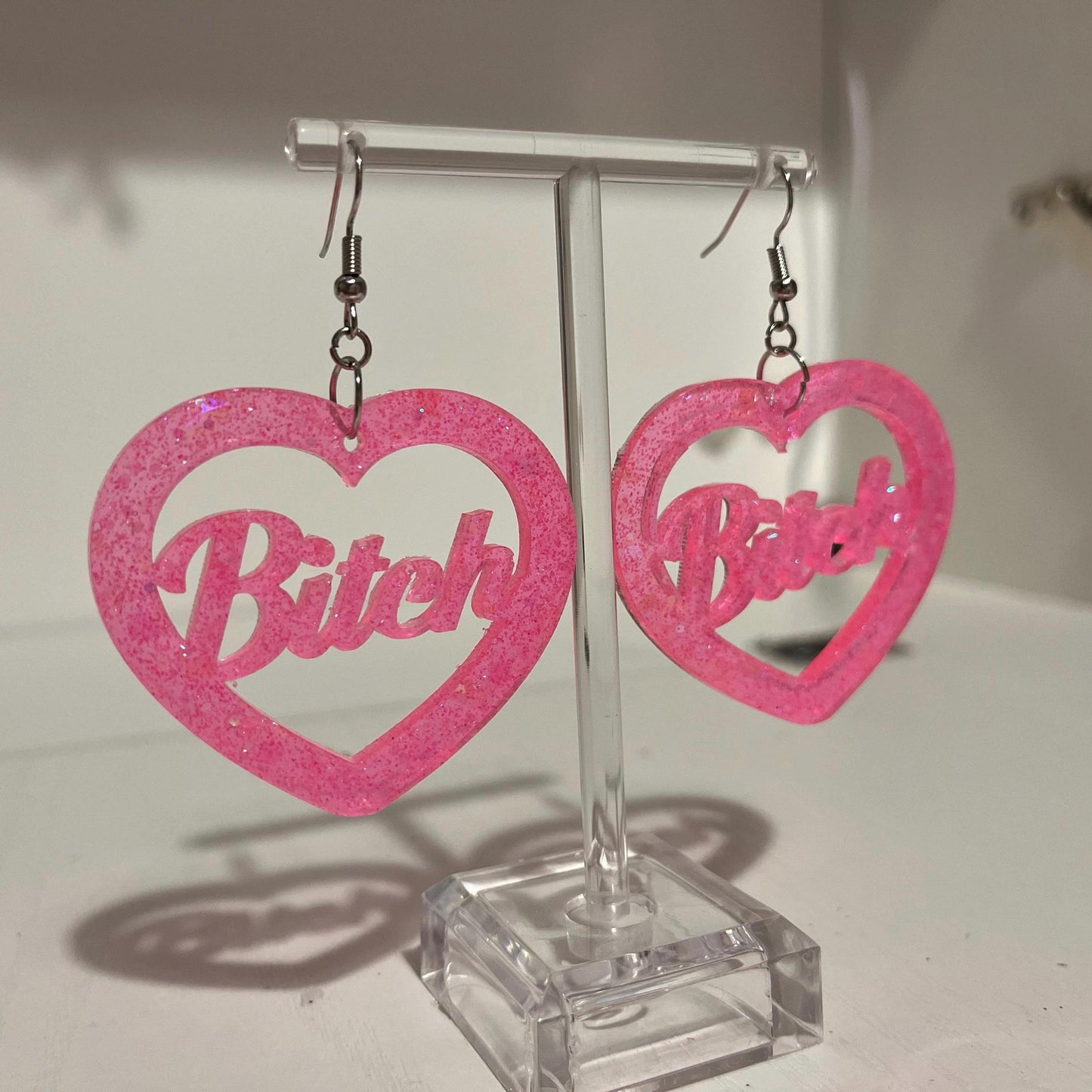 Pink glitter bitch or brat dangle drop earrings or clip ons