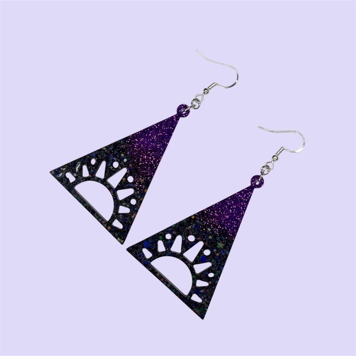 Cosmic vibes dangle drop glittery earrings in black, purple and blue. Silver plated hardware